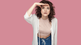 Woman in front of pink wall
