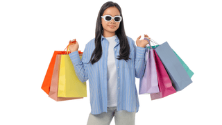 Woman holding colorful shopping bags while wearing trendy sunglasses