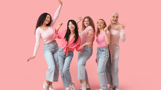 Women having fun in front of a pink background