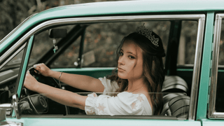 Woman driving wearing a crown