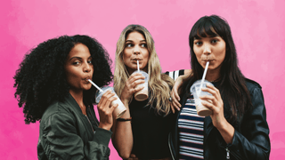 Three women sipping on iced drinks