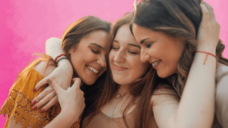 Three woman hugging and smiling