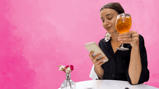 Woman drinking wine and scrolling on her phone
