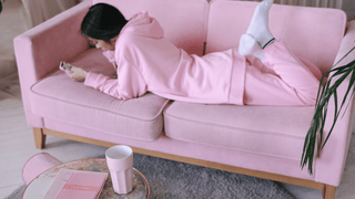 Woman in all pink outfit in a room filled with pink items