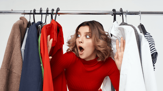 Woman standing by a clothing rack