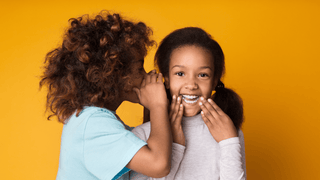 Two little girls whispering