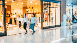 Two women walking through a shopping mall