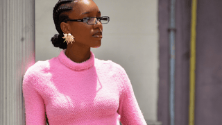 Woman wearing pink sweater and statement earrings
